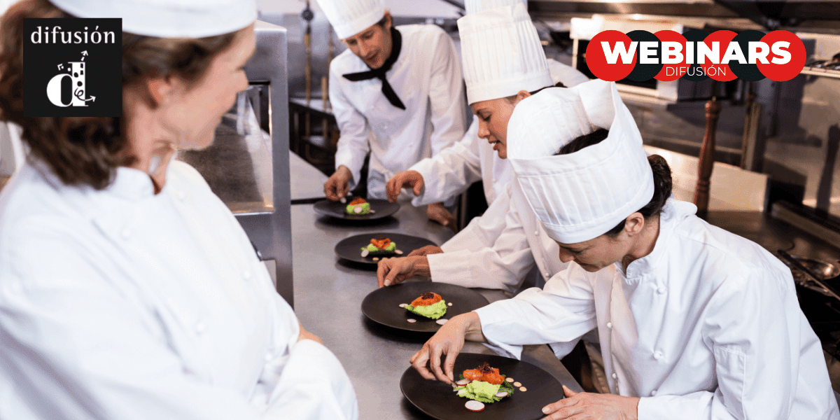Vier koks in witte uniformen serveren gerechten in een professionele keuken. De logo's van Difusión en Webinars zijn zichtbaar.